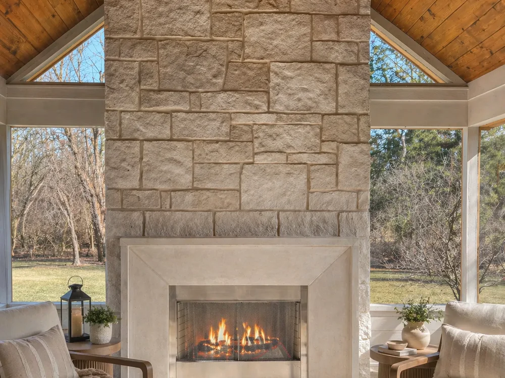 Outdoor covered porch with full-height stacked stone fireplace