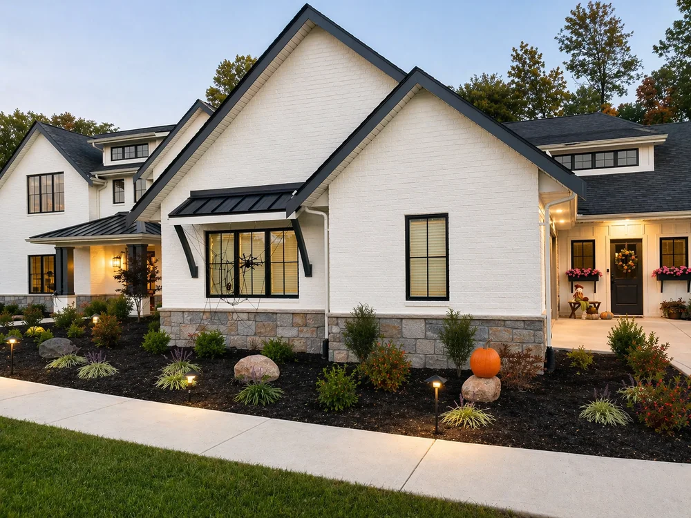 Painted brick custom home at dusk with dark trim and a lit friend entry