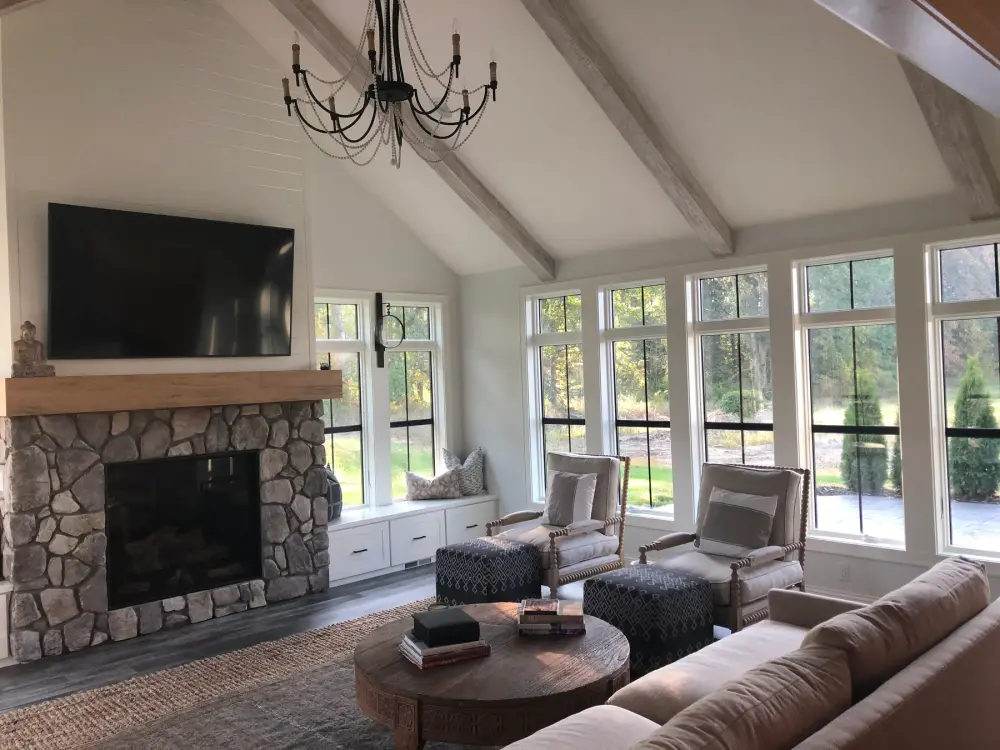 Vaulted great room with exposed wood beams and a stacked stone fireplace